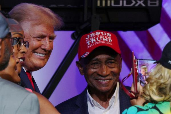 Republican presidential candidate and former U.S. President Do<em></em>nald Trump poses for a photograph with an audience member wearing a hat reading aJesus is my Savior, Trump is my Presidenta after a campaign 