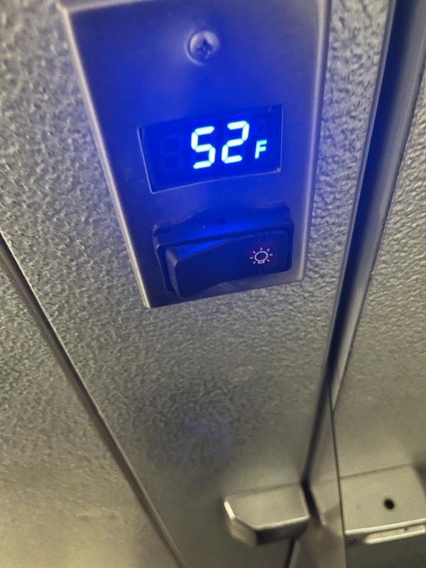 The temperature reading 52 degrees on the fridge at the restaurant