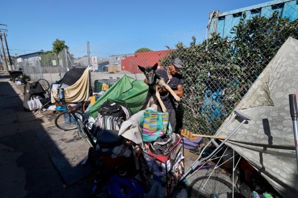 Miguel Angel Go<em></em>nzalez Martinez, 42, and his dog Lincoln, who moved his makeshift tent to the Mars Ct. alley