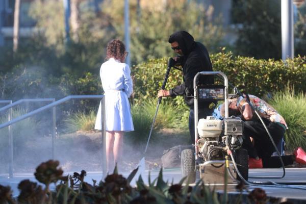 A sanitation worker sprays disinfectant, as the city clears homeless encampments 