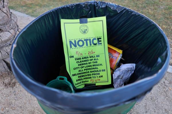 A posted notice sits in the trash at Gumbiner Park, as the city clears homeless encampments 