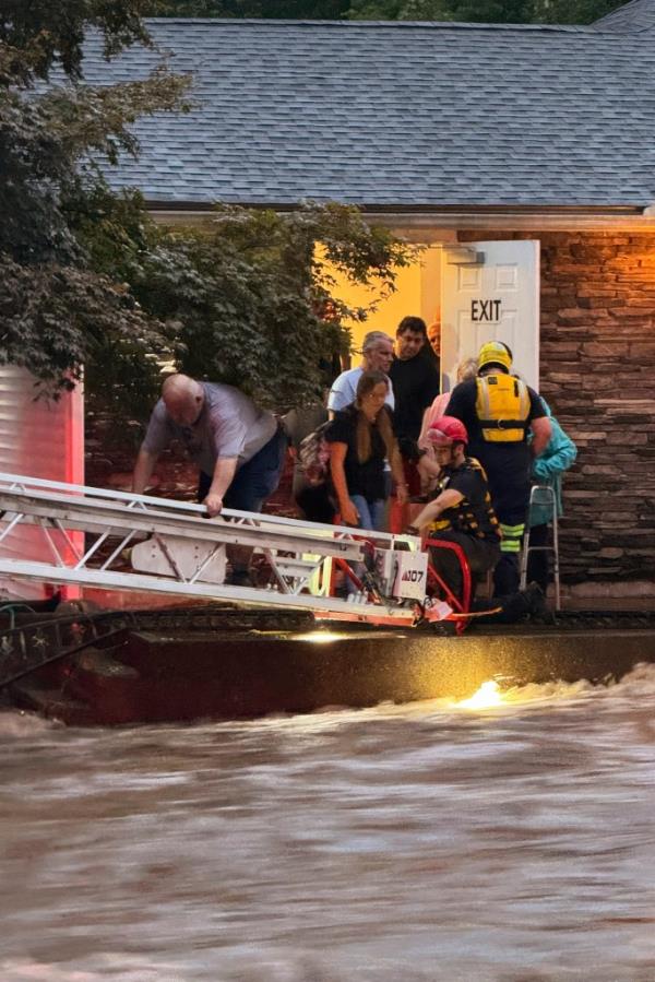 Firefighters from Beacon Hose Co. rescuing individuals by ladder from the flooded Brookside Inn in Oxford, Co<em></em>nnecticut on August 18, 2024