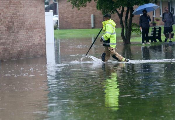 A Danbury firefighters walking through flood waters to search homes during the storm.