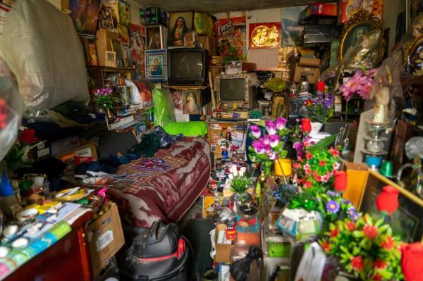 A room cluttered with numerous objects and flowers, depicting compulsive hoarding disorder