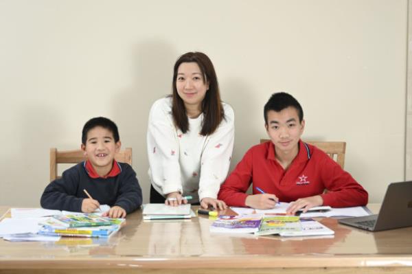 Janice Zheng tutors her sons, Noel, 8, and Evan, 12.