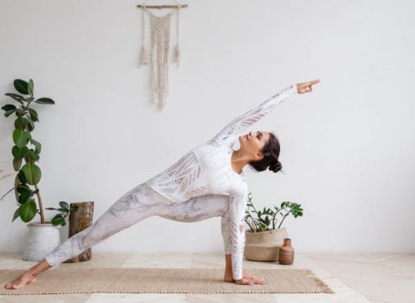 woman doing yoga stretches at home, demo<em></em>nstrating how to boost your mood in the winter