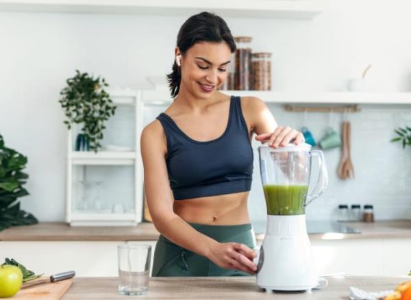 woman making green smoothie, co<em></em>ncept of habits to slim down a thick waist in 30 days