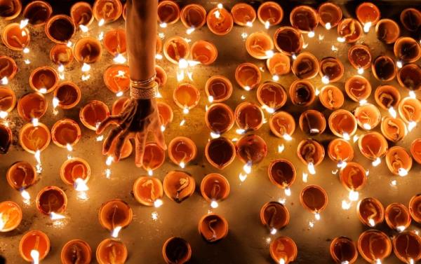 A Tamil devotee lights an oil lamp at a religious ceremony during the Diwali or Deepavali festival at Po<em></em>nnambalavaneshwaram Hindu temple in Colombo, Sri Lanka ,