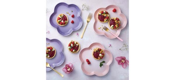 Purple and pink Le Creuset Flower Plates on table